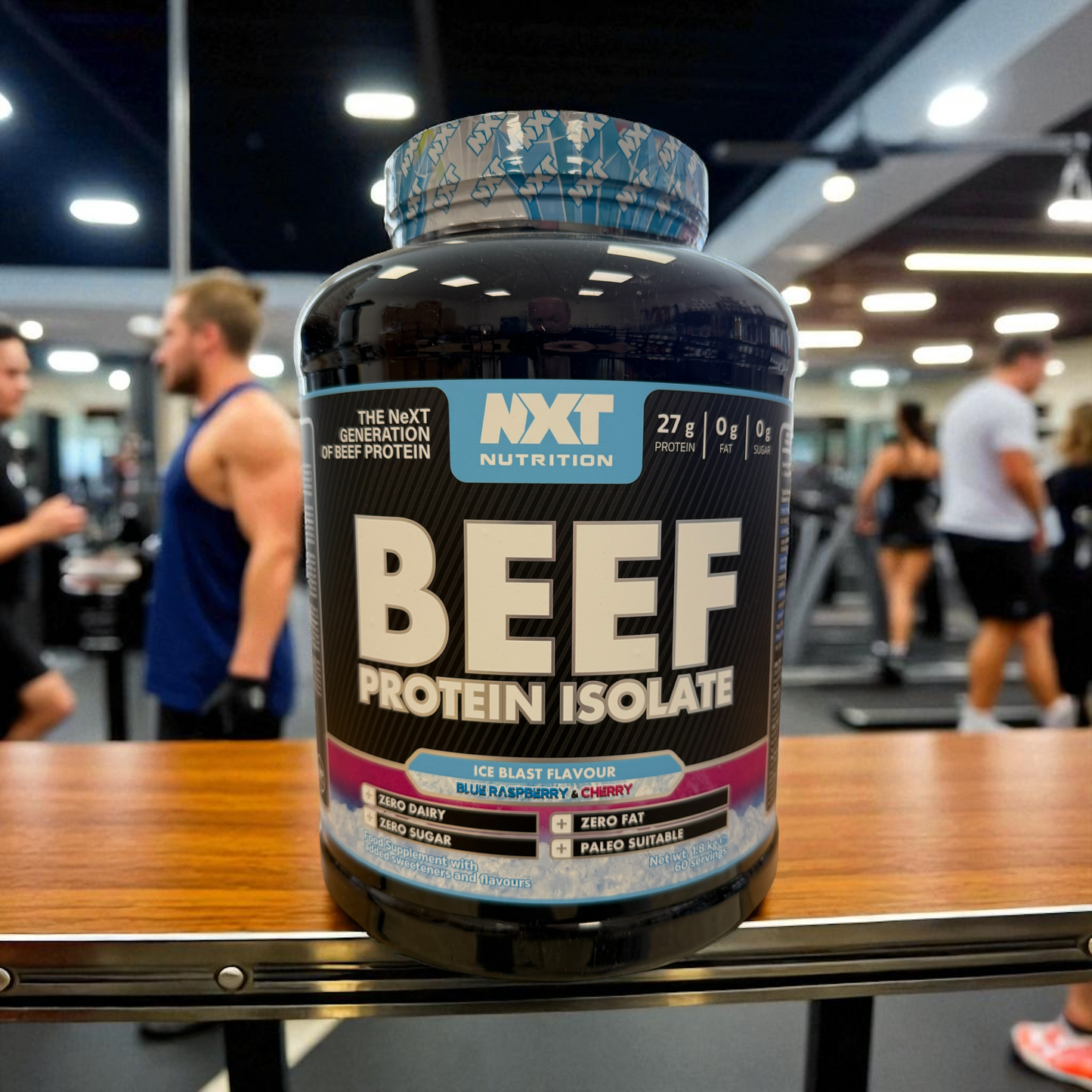 NXT Nutrition Beef Protein Isolate ice blast container on a table in a gym setting