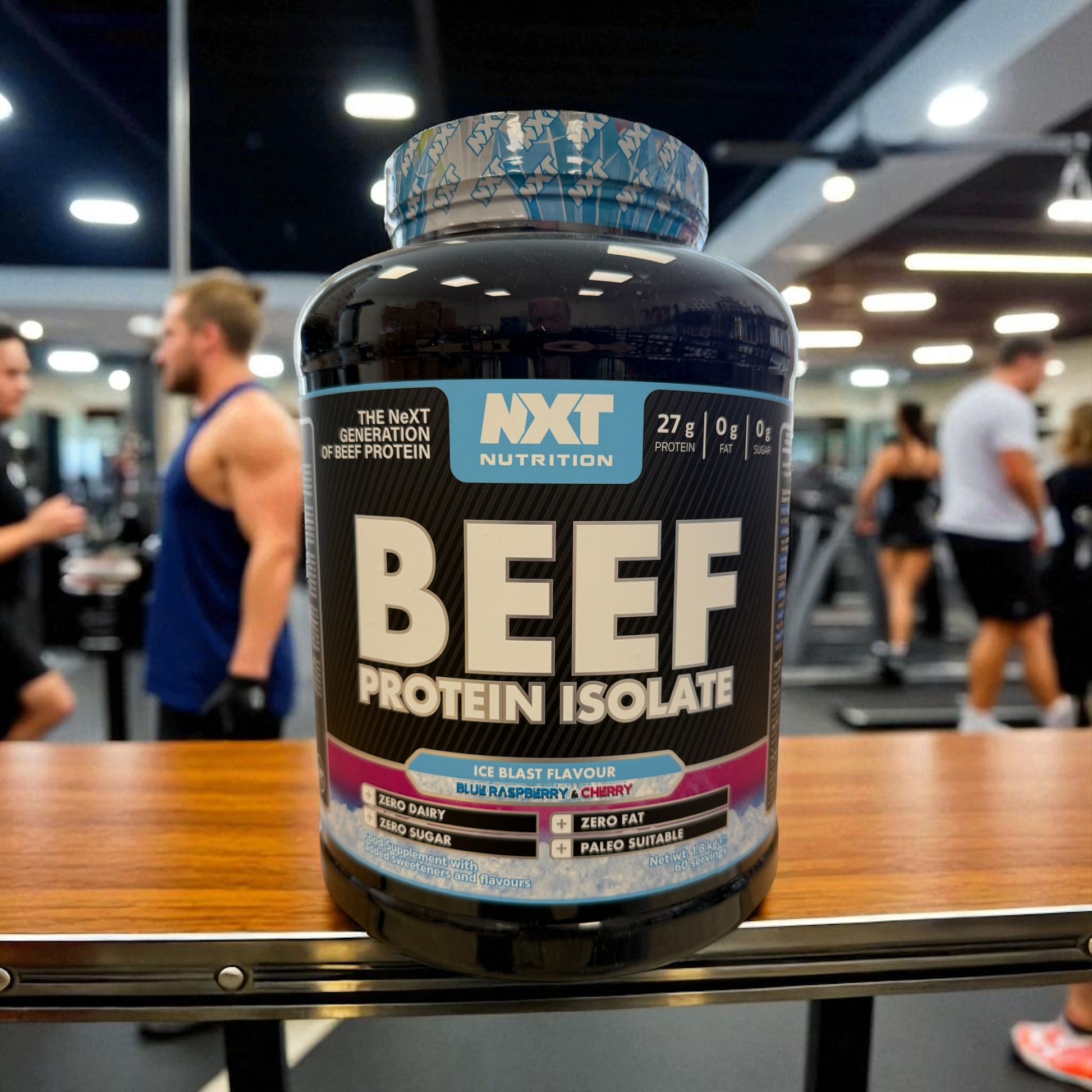 NXT Nutrition Beef Protein Isolate ice blast container on a table in a gym setting